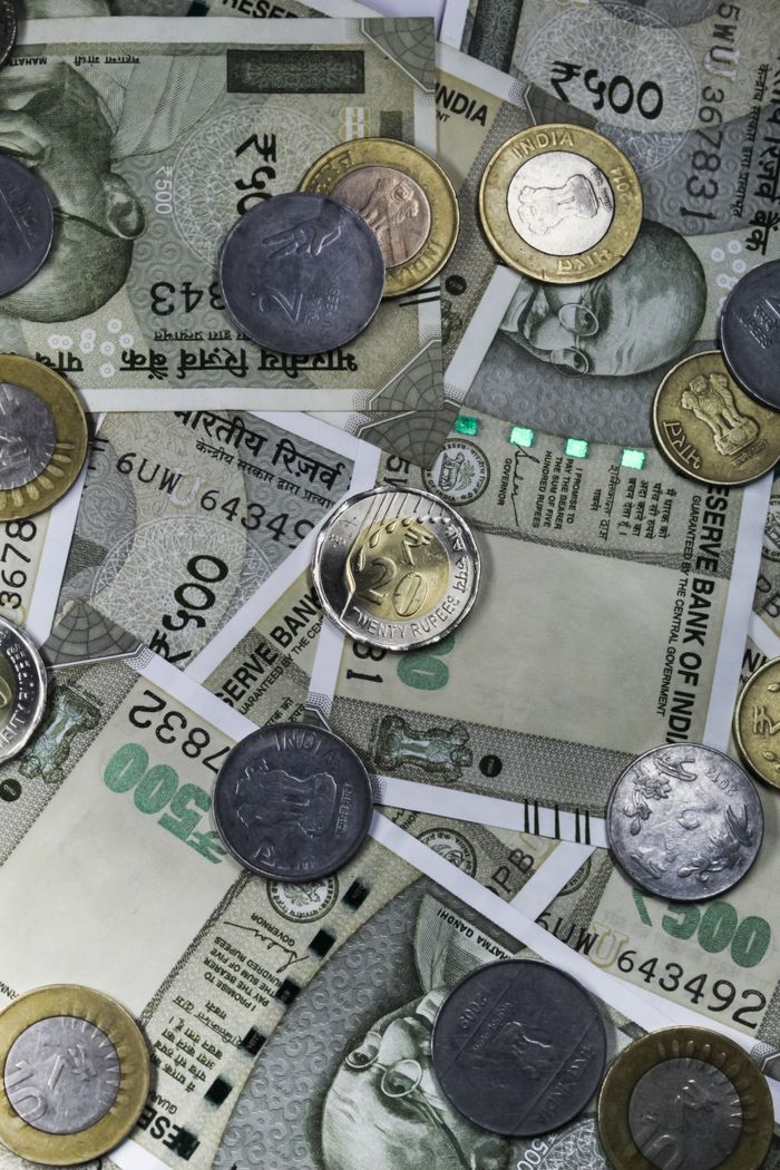 Top view of Indian rupees and coins depicting wealth and finance in India.